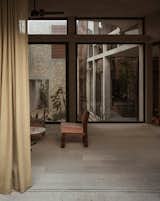 The home is meant to take advantage of its warm and sunny environs. The living room features two walls of glass. One overlooks the dry garden, and the other opens into a courtyard with a jungle garden and a pool that tucks into an archway in the front of the pink casita.