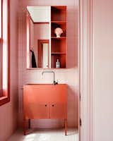 Strongly contrasting colors were used to differentiate bedrooms and bathrooms. The master bath is awash in reddish hues with a custom freestanding vanity by Studio Bright.  Photo 6 of 6 in What’s the Right Fragrance for My Bathroom?