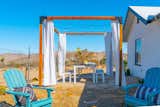 In addition to the covered patio, the desert getaway includes an outdoor dining area situated beneath a Toja Grid pergola.