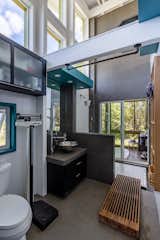 In the bathroom, a walk-in shower connects to an enclosed bath area via sliding glass doors.
