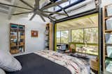 Vertical roll-up doors connect the bedroom to an enclosed veranda-style seating area.