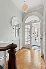 The parlor-level entrance features an arched opening with glazed French doors, as well as parquet floors and plaster molding.