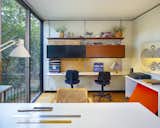 A wall-mounted shelving system in the office offers desk space for two people.
