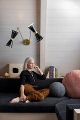 Designer and homeowner Holly Hollenbeck sits on the custom sofa in the Little Owl A-Frame.