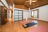 One of the upstairs rooms is currently used as a space for practicing yoga. In total, the 7,617-square-foot home includes five bedrooms, four full baths, and three half baths.