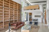 In the sprawling, double-height living room, a built-in bookshelf with a rolling library ladder sits below an open loft.  Photo 4 of 9 in An Architect Couple’s “Experimental House” in the Hollywood Hills Hits the Market for the First Time