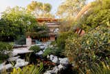 A koi pond and waterfall fountain create a peaceful refuge near the outdoor barbecue area.