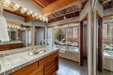 Pale-green tile countertops complement original wooden details in the bathrooms.  Photo 9 of 12 in $1.9M Will Land You This Tastefully Updated “Pop-Top” Model Eichler in the Bay Area