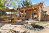 courtyard with a generous covered portal, fireplace, and serene water fountain  Photo 14 of 14 in This Classic Pueblo-Style Home in Santa Fe, New Mexico Could Be Yours for $2.3M