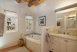 Brick floors and stucco walls continue into the bathrooms.  Photo 9 of 14 in This Classic Pueblo-Style Home in Santa Fe, New Mexico Could Be Yours for $2.3M