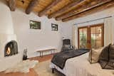 Principal bedroom features its own fireplace and French doors on both sides that connect to outdoor areas  Photo 7 of 14 in This Classic Pueblo-Style Home in Santa Fe, New Mexico Could Be Yours for $2.3M