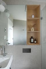 Recessed shelves in the bathroom echo the plywood details in the kitchen.