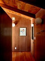 The loft is situated at the end of the wood-paneled hallway upstairs.  Photo 7 of 12 in An Outdoorsy Family’s Bay Area Midcentury Gets an Era-Defying Update