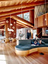 Adam and Karyn Bechtel tasked architect Emily Jagoda with renovating the 1960 home they share with their two daughters in the hills of Woodside, California. A curvilinear, built-in sofa with integrated storage sits below a lofted art studio and angular clerestory windows that frame views of the surrounding trees.  Photo 1 of 12 in An Outdoorsy Family’s Bay Area Midcentury Gets an Era-Defying Update