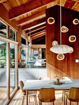 A Nelson Bubble pendant from Design Within Reach hangs above a dining table and chairs by Jasper Morrison for Maruni.  Photo 5 of 12 in An Outdoorsy Family’s Bay Area Midcentury Gets an Era-Defying Update