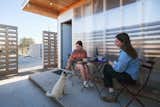 The Hannahs dine with Lange’s dog, Cloudy, on one of the courtyard patios that Rogers added to let tenants take advantage of Marfa’s (mostly) pleasant weather. The metal siding and roofing are from Mueller, while the paint is from Benjamin Moore.  Photo 6 of 8 in The Housing Shortage in Marfa, Texas, Gets Two New Pint-Size Solutions