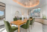 Curvilinear, built-in storage sits below an oval-shaped, recessed ceiling in the dining room.&nbsp;