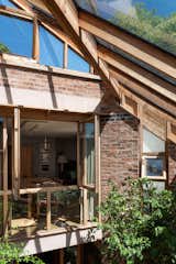 Tall windows connect the living/dining area to the upper level open directly onto the garden at one side, with the second set of glazing doors opening onto the upper conservatory.