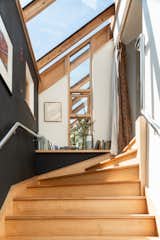 A staircase capped with large skylights leads to a guest bedroom and workshop/office.