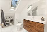 A large, slanted skylight illuminates one of the two bathrooms.