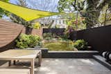 Sliding glass doors connect the kitchen/dining area to a bluestone patio and landscaped yard.  Photo 18 of 18 in After a 15-Year Renovation, an Architect Couple List Their Brooklyn Townhouse