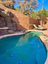 Tall, undulating adobe-and-stucco walls surround the outdoor pool area.