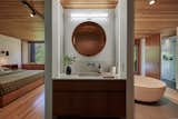 A custom vanity separates the sleeping area from the luxurious en suite bath, which includes a freestanding tub and a walk-in shower with a heated floor.  Photo 10 of 14 in A Japanese-Influenced Midcentury Lists for $1.5M in Portland, OR