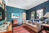 One of the side rooms features deep teal wallpaper, as well as easy access to the backyard.