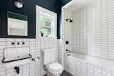 The bathroom maintains the light and bright atmosphere with subway tile, as well as a vintage inspired sink.