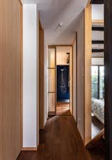 A translucent glass door leads to the primary suite and yoga room. The walk-in shower is lined in dark blue fiberglass; the fixtures are from Sanwa.