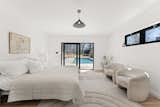 The primary bedroom suite opens directly to the pool via an oversized sliding door.