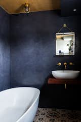 Deep navy lime-wash walls together with Victorian tiles add alluring charm to this en suite bath.&nbsp;