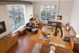 The living room features hardwood floors and lots of natural light from the studio windows.&nbsp;