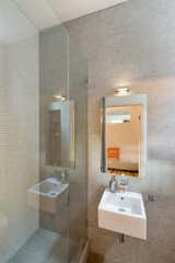 The bathroom found in the second bedroom features tile of various scales in a beige colorway.&nbsp;