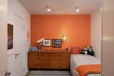 The third bedroom embraces a pop of color, with a bright orange paint prominently gracing one of the walls.&nbsp;
