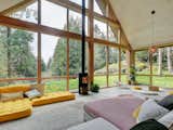The minimalist fireplace is framed by floor-to-ceiling windows, which bring plenty of light into the living room.&nbsp;