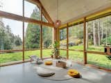 A corner for rest and relaxation takes in many natural offerings, like the sun, trees, rocky landscape, and grass.&nbsp;