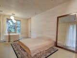 Just past the kitchen, there’s a bedroom with a freestanding bathtub and large windows.