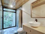 Just past the living room, a bathroom with full nature views opens to the forest.&nbsp;