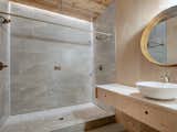 The newly attached bathroom of this home features a tiled shower, as well as the low-impact wood found in the other parts of the home.