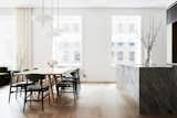 12-inch white oak floors help highlight and dramatize the scale of the apartment, along with a blocky marble island counter.  Photo 1 of 3 in A Triangular Union Square Apartment Gets a Timeless Transformation