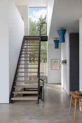 A dramatic steel staircase may take you up to the loft style living area and bedrooms or down to a lower level reading room.