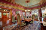 In the dining room, a mix of cool and warm colors ground the space, and large windows provide plenty of light.