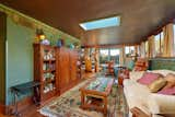 In another bedroom, a sizable skylight and windows illuminate the verdant wallpaper.