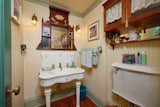 The bathroom continues the ode to Victorian architecture, with its period correct sink, mirror, and light fixtures.