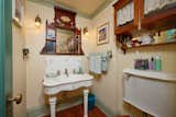 The bathroom continues the ode to Victorian architecture, providing a period correct sink and mirror, as well as light fixtures.  Photo 16 of 23 in Asking $2M, a Striking Victorian-Style Home in San Diego Features All Its Original Trimmings