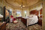 In one of the bedrooms, intricate details are found on both the carpeted floor and the ceiling, featuring motifs of floral elements.