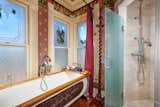 Not shying away from a bit of modernity, the bathroom, with it's frosted glass and subway tiled shower, sits nicely along a vintage freestanding tub.  Photo 18 of 23 in Asking $2M, a Striking Victorian-Style Home in San Diego Features All Its Original Trimmings