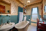 In the attached bathroom, a muted turquoise sits alongside another vintage pattern. A frosted glass window brings in both fresh air and light.  Photo 21 of 23 in Asking $2M, a Striking Victorian-Style Home in San Diego Features All Its Original Trimmings