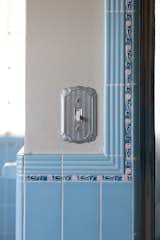 Vibrantly detailed blue tiles add character to this bathroom—as does the silver switch plate.&nbsp;